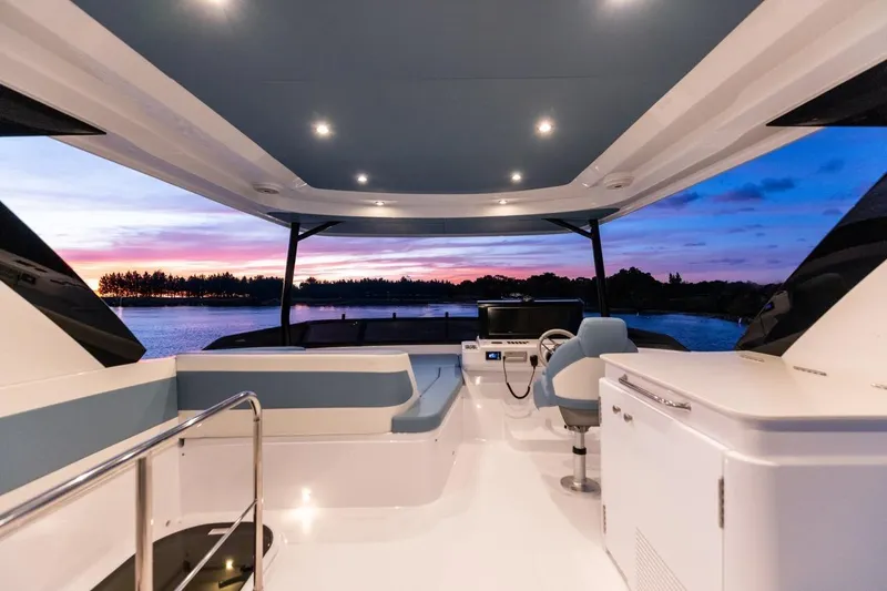 Slide: The Image of Luxurious 2026 Cruisers Yachts 50 Fly interior with sunset view over water. - 80
