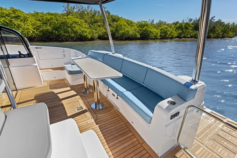 Slide: The Image of Luxurious 2026 Cruisers Yachts 50 Fly deck with seating, table, and scenic water view. - 86