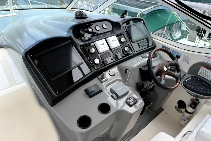 Slide: The Image of 2005 Cruisers Yachts 405 Express Motoryacht helm with navigation controls and steering wheel. - 10