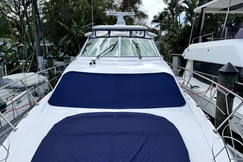 Slide: The Image of 2005 Cruisers Yachts 405 Express Motoryacht docked, featuring blue covers and sleek design. - 4