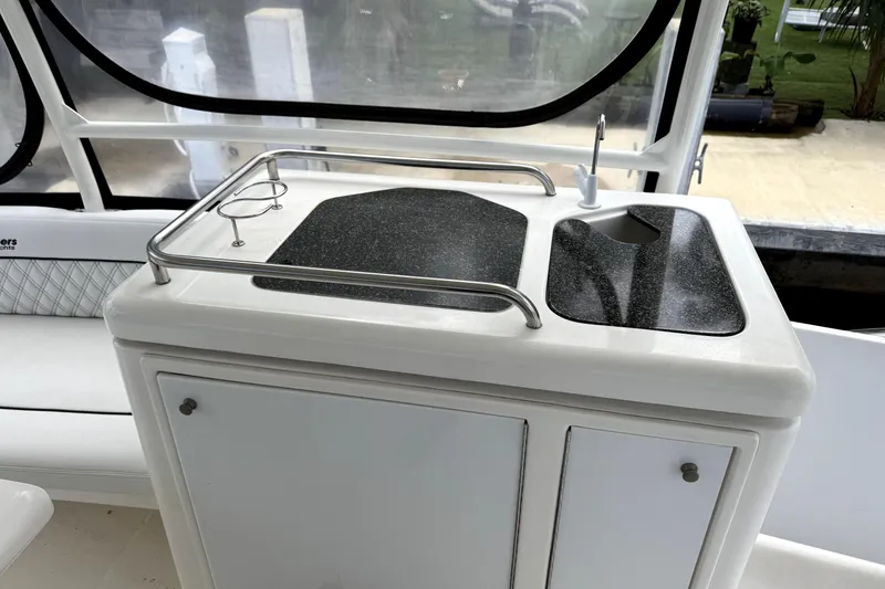 Slide: The Image of 2005 Cruisers Yachts 405 Express Motoryacht kitchenette with sink and storage cabinets. - 8