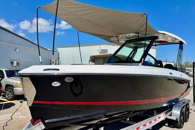 Slide: The Image of 2026 Monterey Elite 25 OB boat with canopy on trailer, parked outdoors. - 21