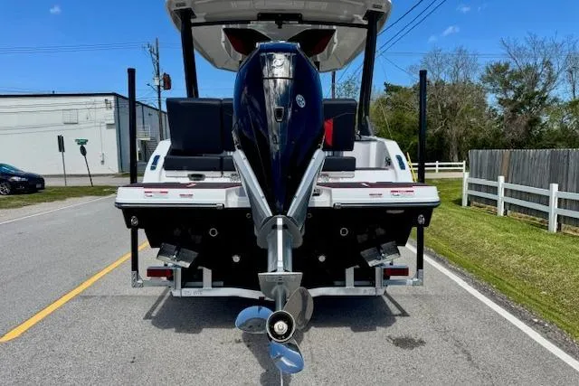 Slide: The Image of 2026 Monterey Elite 25 OB boat with outboard motor on a trailer, parked on a street. - 3