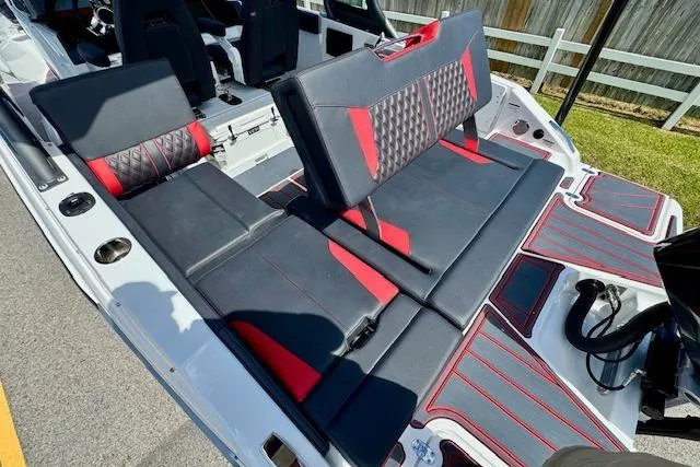 Slide: The Image of 2026 Monterey Elite 25 OB boat interior with black and red seating, showcasing modern design. - 9