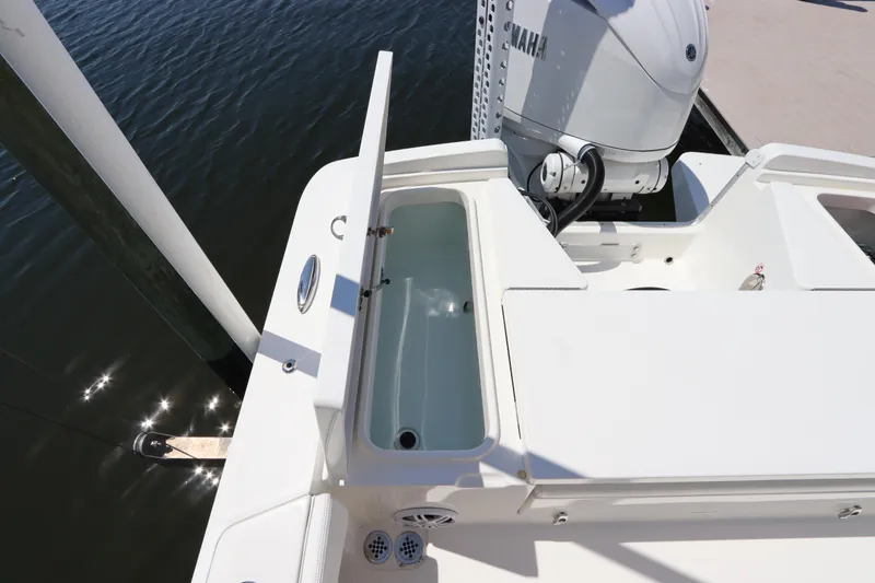 Slide: The Image of 2021 Regulator 24XO boat with open storage compartment and Yamaha engine. - 11