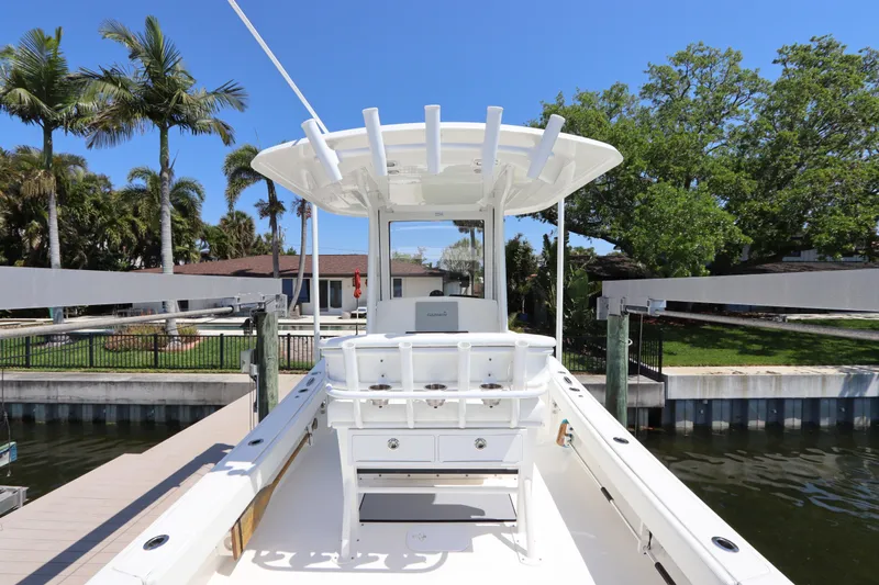 Slide: The Image of 2021 Regulator 24XO boat docked, featuring a sleek white design and spacious deck. - 14