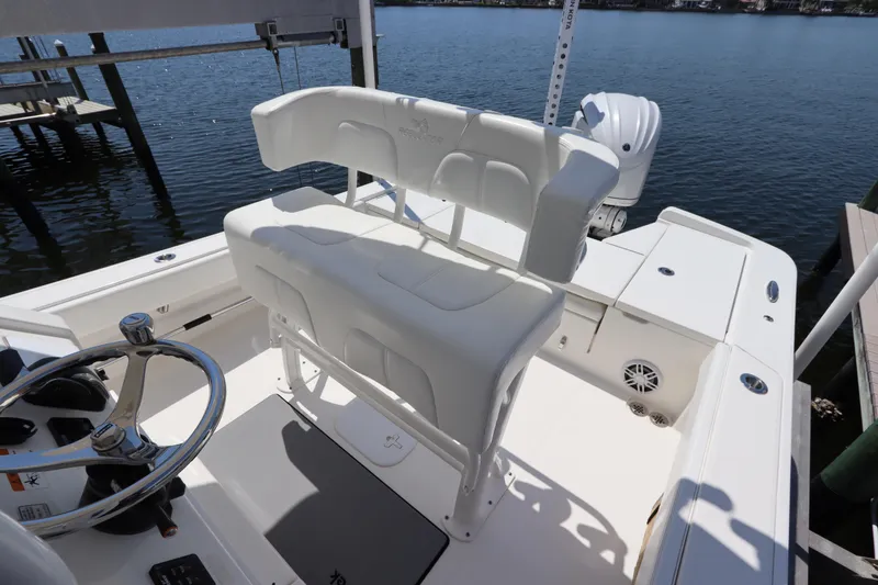 Slide: The Image of 2021 Regulator 24XO boat interior with helm seat and steering wheel, docked by the water. - 15