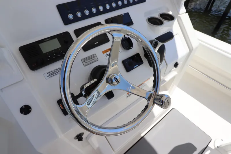 Slide: The Image of 2021 Regulator 24XO boat helm with steering wheel and control panel. - 21
