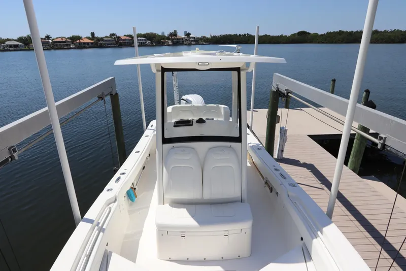 Slide: The Image of 2021 Regulator 24XO boat docked by a serene waterfront, showcasing sleek design and spacious deck. - 36