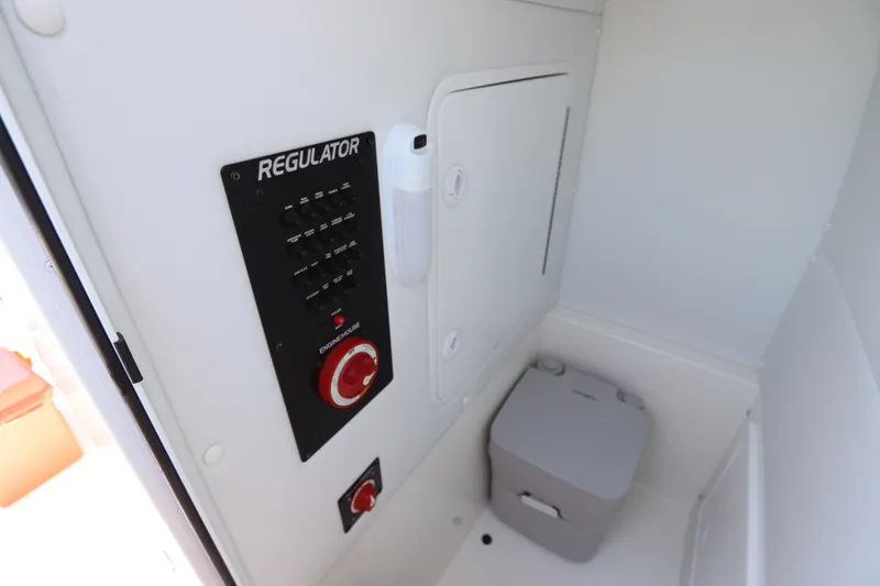 Slide: The Image of 2021 Regulator 24XO boat interior with control panel and portable toilet. - 40