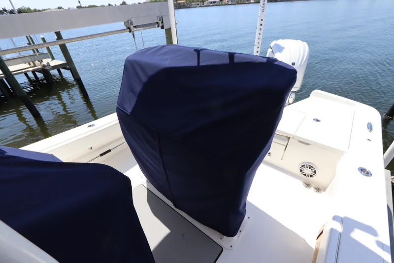 Slide: The Image of 2021 Regulator 24XO boat with covered seats, docked by the water. - 41