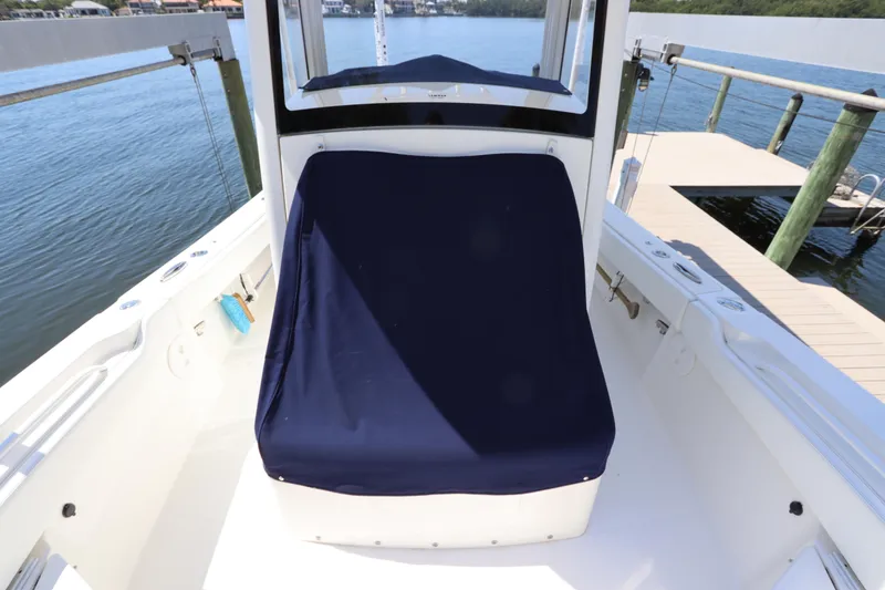 Slide: The Image of 2021 Regulator 24XO boat interior with navy seat cover, docked by the water. - 43