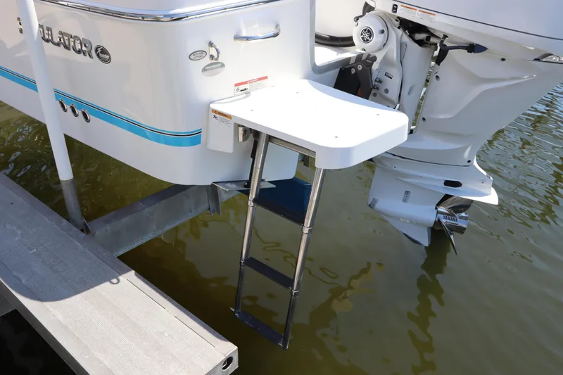 Slide: The Image of 2021 Regulator 24XO boat with swim platform and ladder, docked by the water. - 6