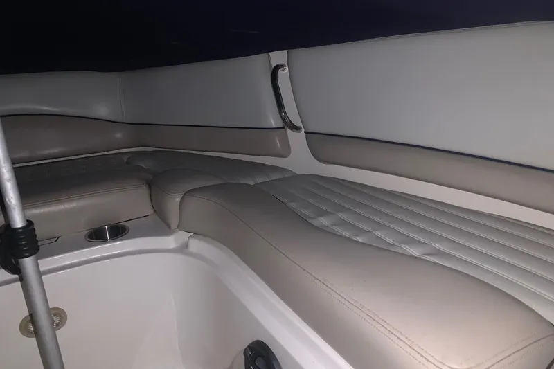 Slide: The Image of Interior seating of a 2007 Bryant 270 boat, featuring beige upholstery and cup holder. - 11
