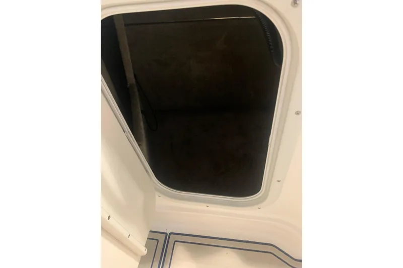 Slide: The Image of Hatch opening on a 2007 Bryant 270 boat, showing interior storage space. - 17