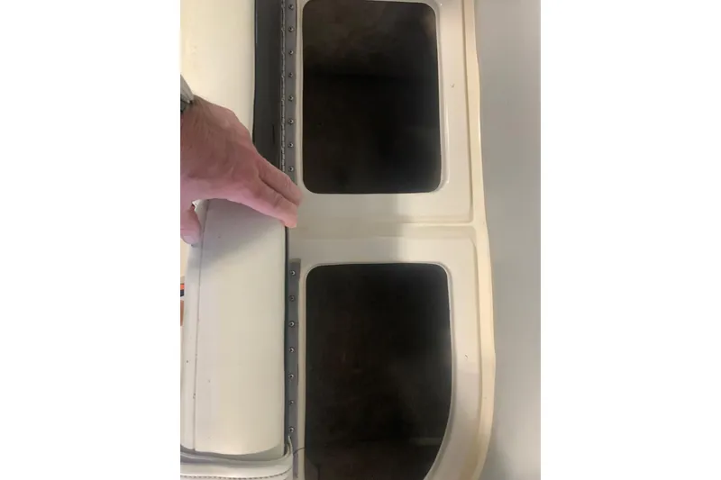 Slide: The Image of Hand inspecting storage compartments on a 2007 Bryant 270 boat. - 18