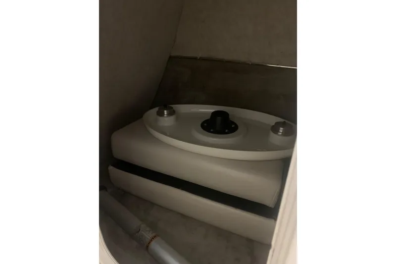 Slide: The Image of Storage compartment in a 2007 Bryant 270 boat, featuring a white tank and piping. - 19