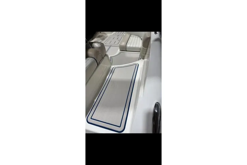 Slide: The Image of Interior view of a 2007 Bryant 270 boat, featuring white seating and deck area. - 27