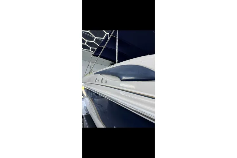 Slide: The Image of 2007 Bryant 270 boat with sleek blue and white design, docked indoors. - 31