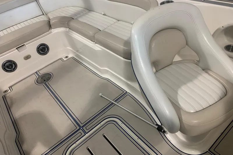 Slide: The Image of Interior of a 2007 Bryant 270 boat featuring white seating and deck details. - 6