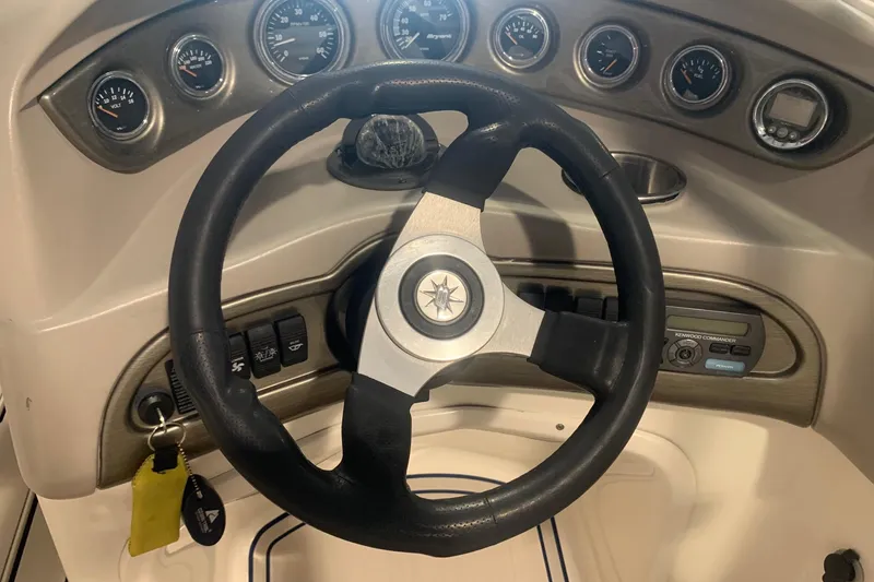 Slide: The Image of Steering wheel and dashboard of a 2007 Bryant 270 boat with gauges and controls. - 8