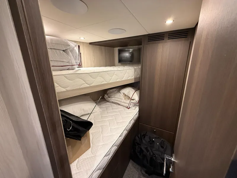 Slide: The Image of Bunk beds in the 2026 Azimut Magellano 25M yacht cabin, featuring modern wood paneling. - 49