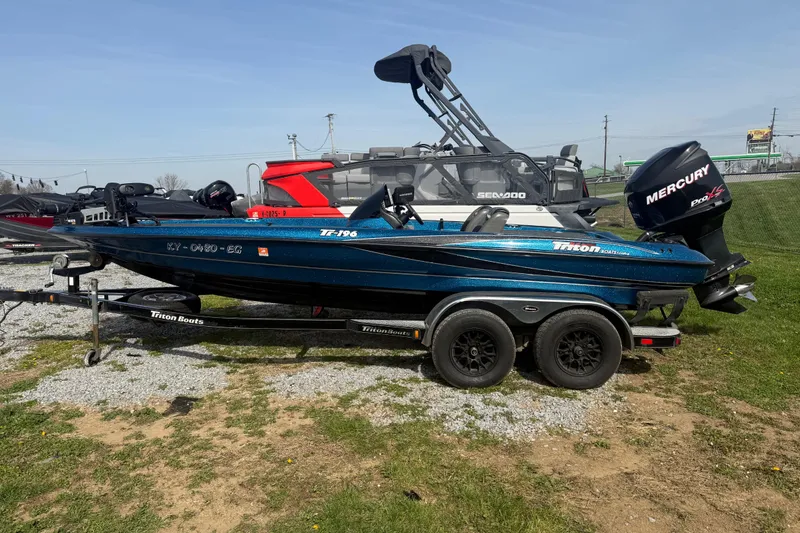 The Image of 2006 Triton Tr-196 SC boat with Mercury engine on trailer, parked outdoors. - 1