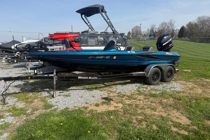 Slide: The Image of 2006 Triton Tr-196 SC boat on trailer, parked on grass and gravel. - 3