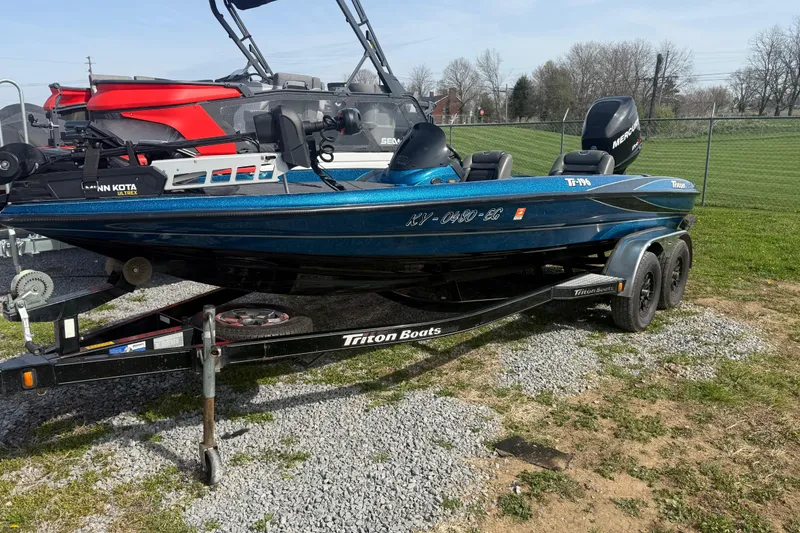 Slide: The Image of 2006 Triton Tr-196 SC boat on trailer, parked on gravel near a fence. - 4