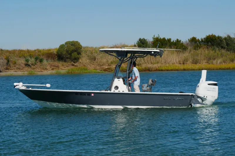 Slide: The Image of 2023 Sea Born FX24 Bay boat cruising on a calm waterway. - 2