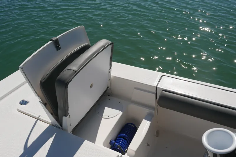 Slide: The Image of 2023 Sea Born FX24 Bay boat interior with seating and storage, on sparkling water. - 26