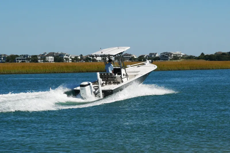 Slide: The Image of 2023 Sea Born FX24 Bay boat cruising on a scenic waterway. - 5