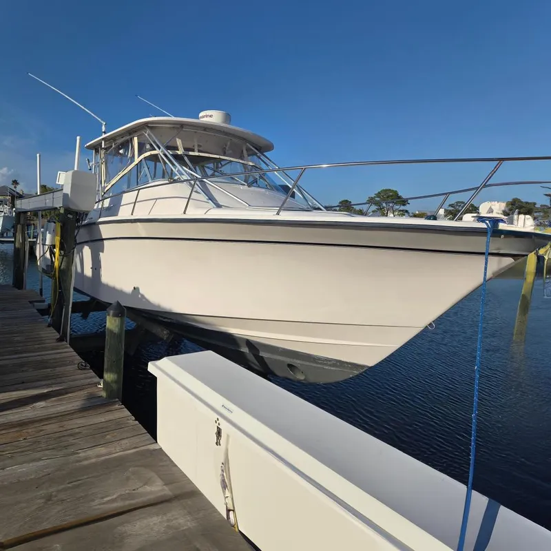 The Image of 2004 Grady-White Express 330 boat docked at a marina under clear blue skies. - 0