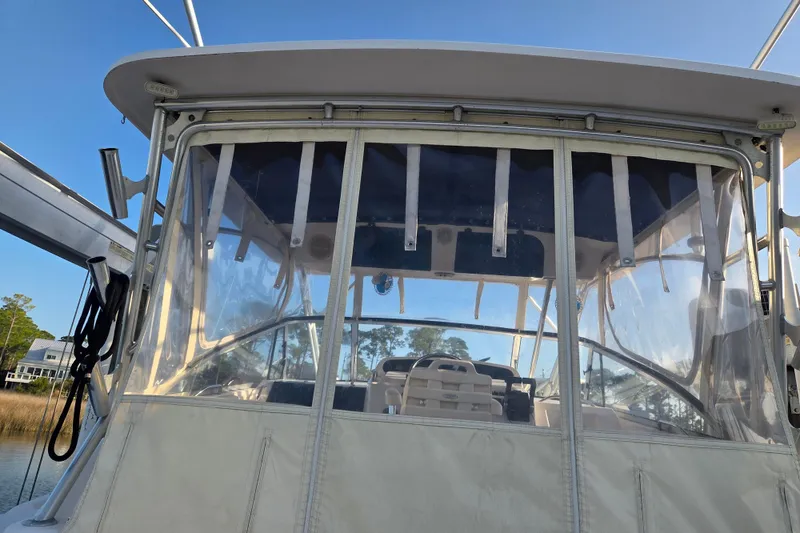 Slide: The Image of 2004 Grady-White Express 330 boat with clear enclosure and visible seating area. - 14