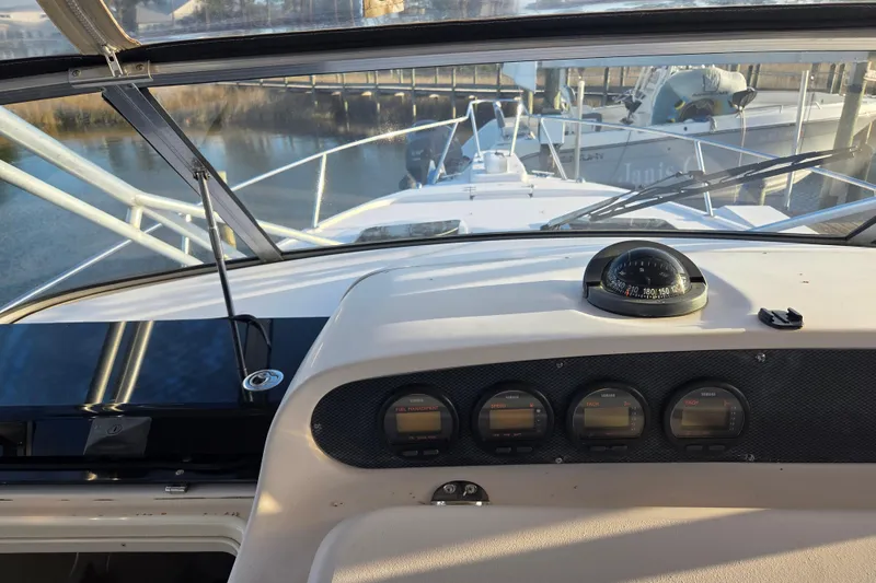 Slide: The Image of 2004 Grady-White Express 330 boat dashboard with compass and gauges in marina setting. - 18