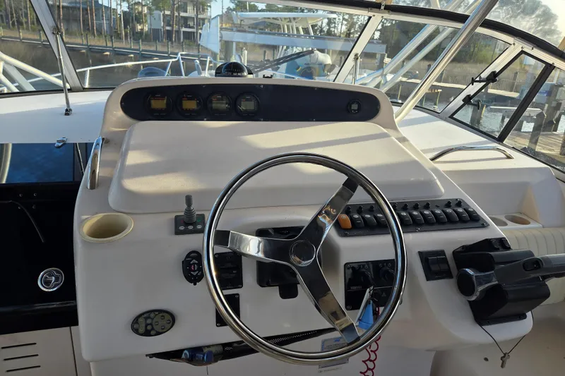 Slide: The Image of Helm of 2004 Grady-White Express 330 boat with steering wheel and controls. - 19