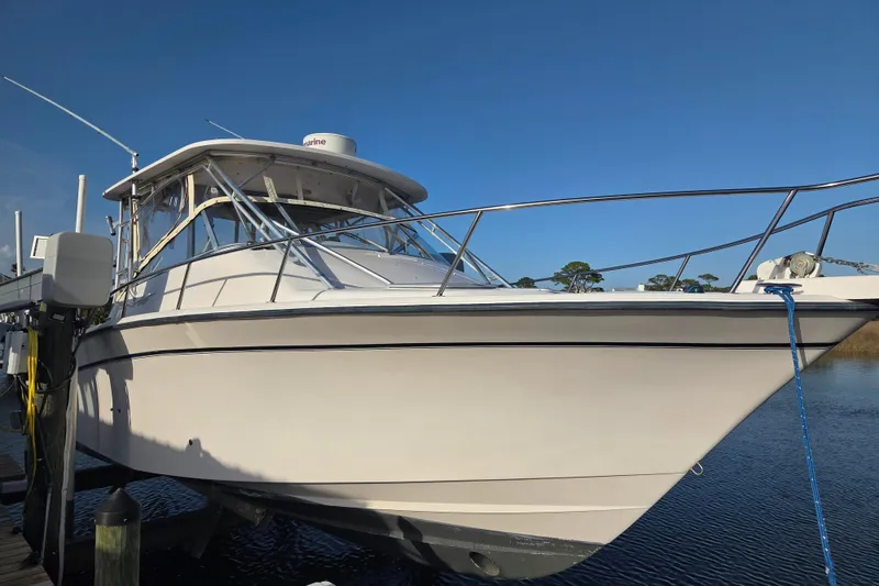 Slide: The Image of 2004 Grady-White Express 330 boat docked on calm water under clear blue sky. - 2