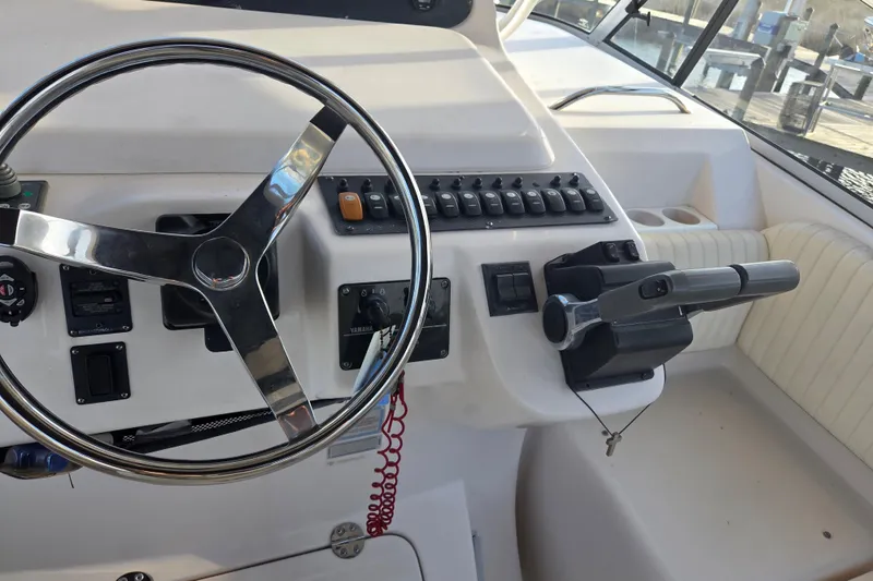 Slide: The Image of Helm of 2004 Grady-White Express 330 boat with steering wheel and control panel. - 20