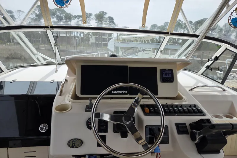 Slide: The Image of 2004 Grady-White Express 330 helm with Raymarine electronics and steering wheel. - 21