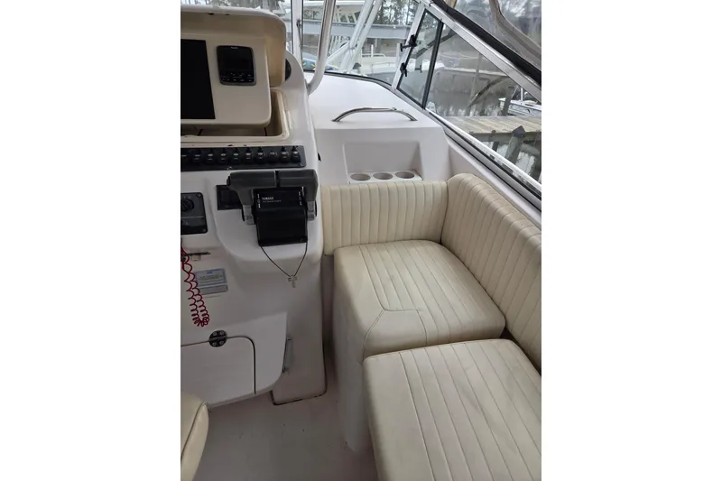 Slide: The Image of 2004 Grady-White Express 330 boat interior with helm and cushioned seating. - 25
