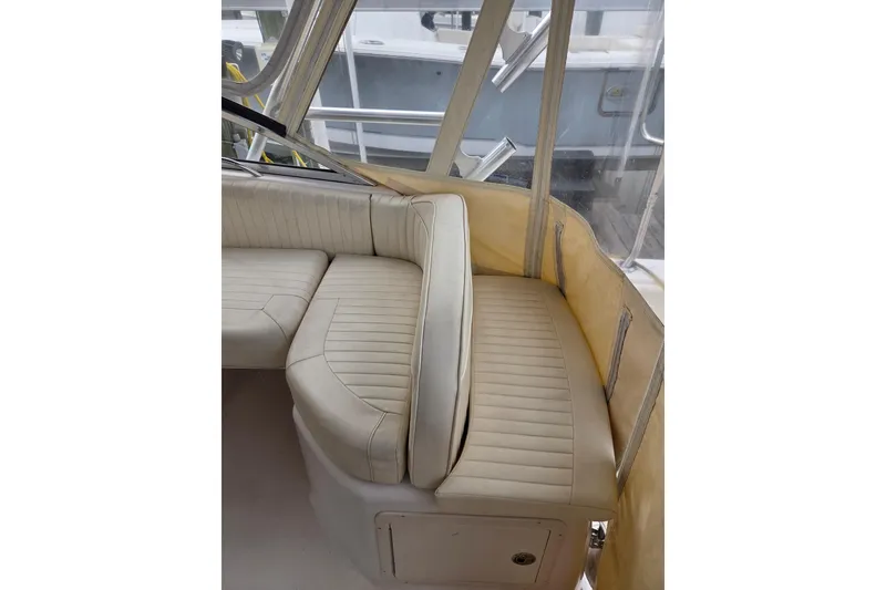 Slide: The Image of 2004 Grady-White Express 330 boat interior with beige seating and clear enclosure. - 27