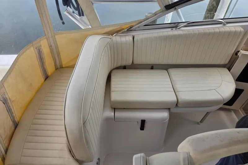 Slide: The Image of 2004 Grady-White Express 330 boat interior with white cushioned seating. - 28