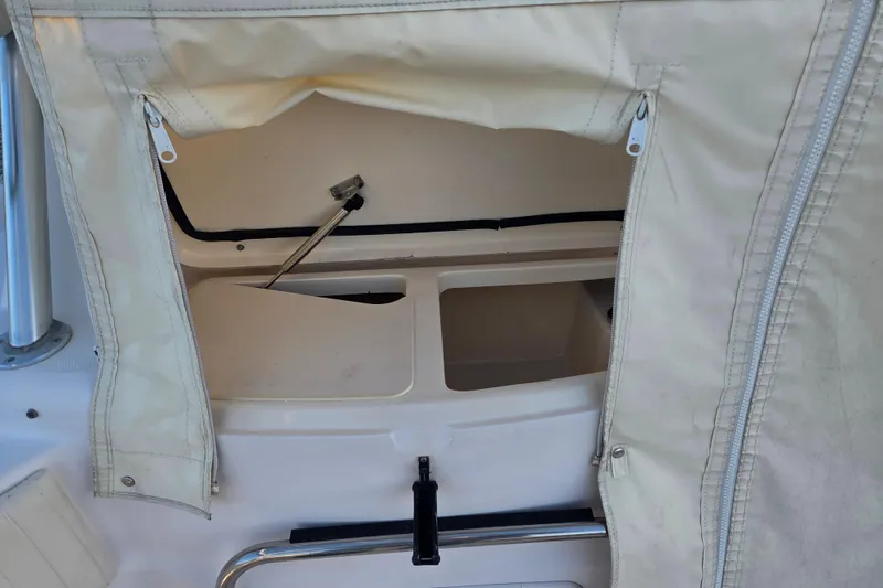 Slide: The Image of 2004 Grady-White Express 330 boat interior storage compartment with beige cover and zippers. - 32