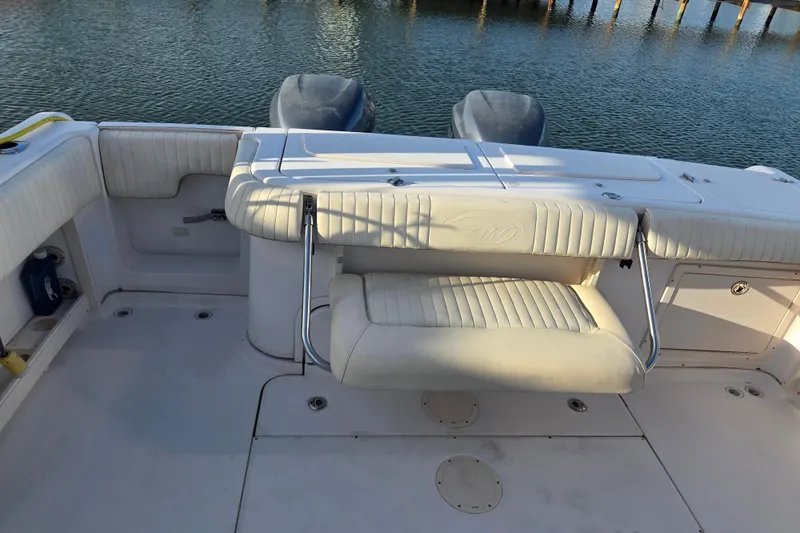 Slide: The Image of 2004 Grady-White Express 330 boat interior with cushioned seating and twin engines. - 37