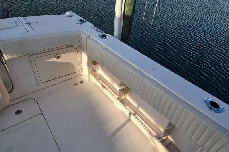 Slide: The Image of 2004 Grady-White Express 330 boat deck with cushioned seating and storage compartments. - 42