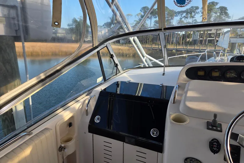 Slide: The Image of 2004 Grady-White Express 330 boat cockpit with steering wheel and control panel. - 45