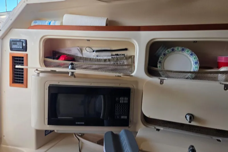 Slide: The Image of Interior of a 2004 Grady-White Express 330 boat with microwave and storage compartments. - 47