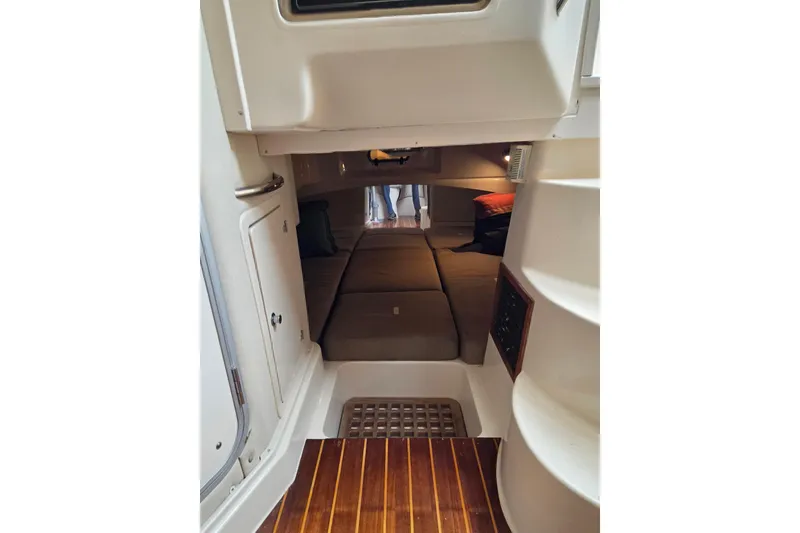 Slide: The Image of 2004 Grady-White Express 330 cabin interior with cozy sleeping area and wooden flooring. - 49