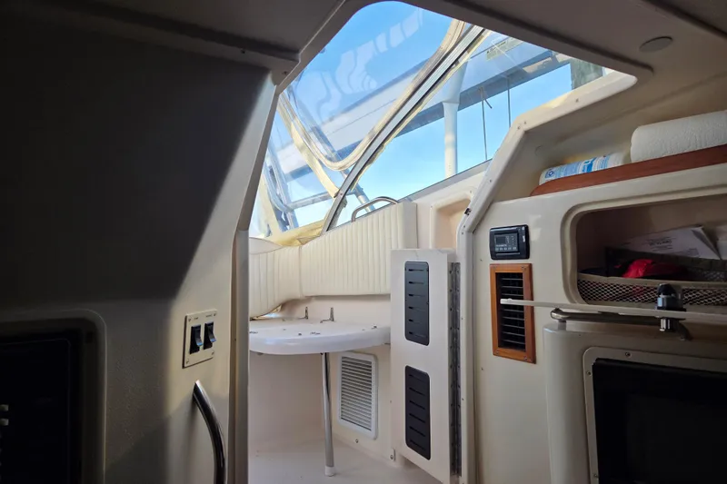 Slide: The Image of Interior view of a 2004 Grady-White Express 330 boat cabin with helm and storage. - 52