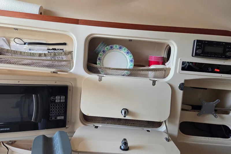 Slide: The Image of Interior of a 2004 Grady-White Express 330 boat with microwave and storage compartments. - 53